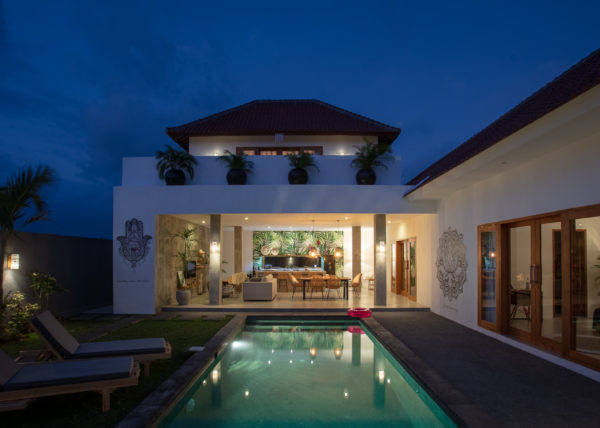 Villa ABSOLUTE – View from the pool of the living room, kitchen and dining room by nights